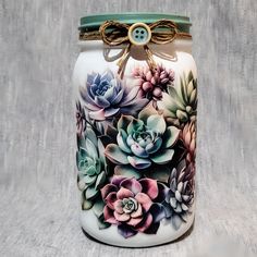 a painted jar with succulents on it and a bow around the lid