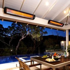 an outdoor dining area with table, chairs and heater on the roof above it