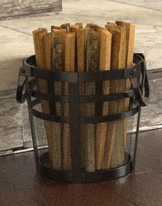 a basket filled with wood sticks on top of a wooden table