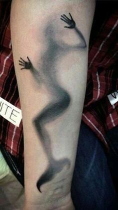 a person with a black and white tattoo on their arm that has an image of a hand coming out of it