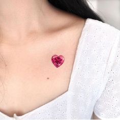 a woman with a pink heart tattoo on her chest