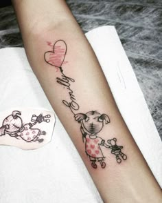 a woman's arm with a dog and heart shaped balloon tattoo on the wrist