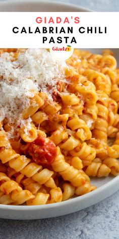 a white bowl filled with pasta covered in sauce and parmesan cheese on top