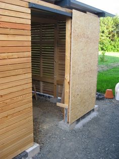 a small wooden building sitting on top of a gravel field