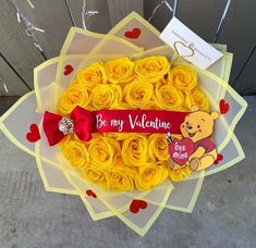 a bouquet of yellow roses with a winnie the pooh sticker on it's side