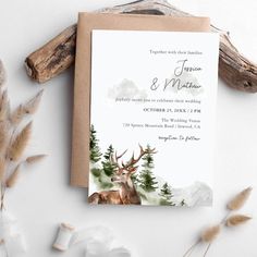 a wedding card with an image of a deer in the woods and pine trees on it