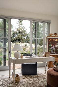 a living room filled with furniture and large windows