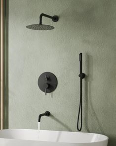 a white sink sitting under a faucet next to a wall mounted shower head