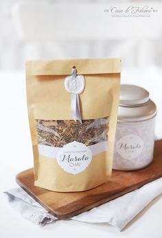 a bag of tea sitting on top of a wooden cutting board next to a jar