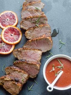 sliced meat with blood oranges and garnish on the side next to it