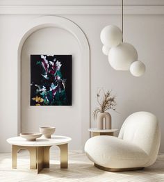 a living room with white furniture and art on the wall, including an oval coffee table