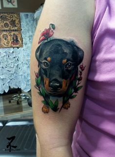 a woman's arm with a tattoo of a black and brown dog on it