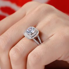 a woman's hand with a diamond ring on top of her finger and an engagement band