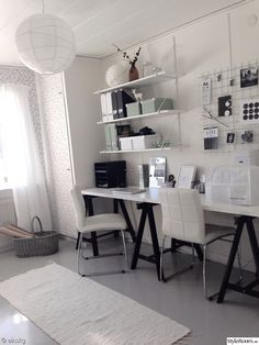 a white desk and chair in a small room with shelves on the wall behind it