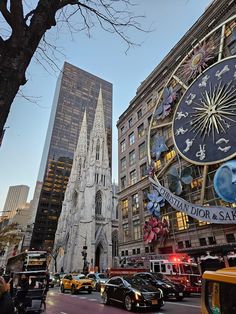 a large clock on the side of a building with cars parked in front of it