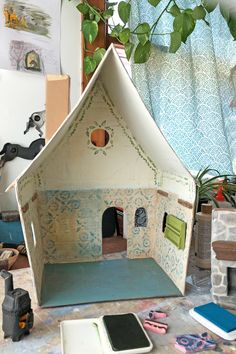 a doll house made out of cardboard sitting on top of a table