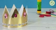 a paper crown sitting on top of a table next to some markers and pencils