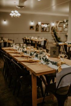 a long table is set up with place settings and candles for an elegant wedding reception