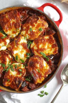 a pan filled with meat and cheese covered in sauce