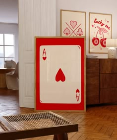 two framed cards are sitting on the floor in front of a wooden table and chair