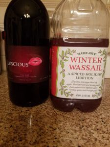 two bottles of wine sitting on top of a counter next to a bottle of liquid