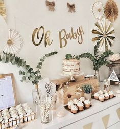 a dessert table with cupcakes, cakes and other items on it at a baby's first birthday party