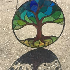 a stained glass tree hanging from a chain