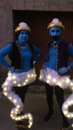 two people dressed in costumes standing next to each other with lights on their heads and arms