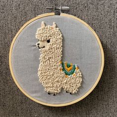 a white embroidered llama on a gray background