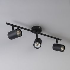 three spotlights are mounted on the ceiling in an industrial style lighting fixture that is black