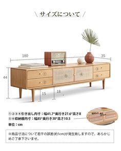 the sideboard with drawers has an alarm clock on it and is next to a potted plant