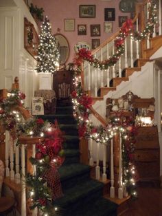 christmas decorations on the banisters and stairs in a house decorated with garland, poinsettis and lights