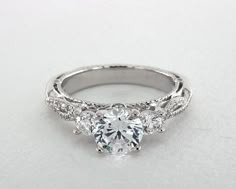 a three stone engagement ring with diamonds on the band and side stones in the center