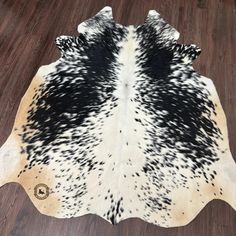 black and white cowhide rug on wooden floor