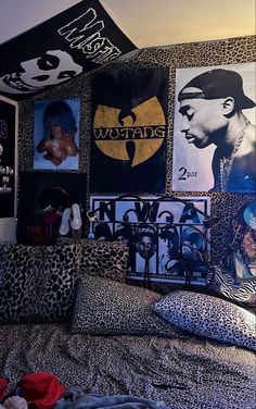 a bedroom with posters on the wall and leopard print bedding