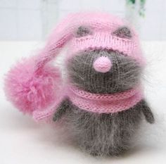 a small gray and pink stuffed animal with a pink hat on it's head