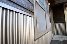 an open window on the side of a building next to a metal wall and door