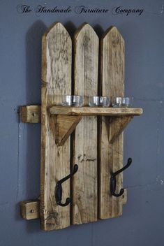 a wooden shelf with two glasses on it and an umbrella hook attached to the wall