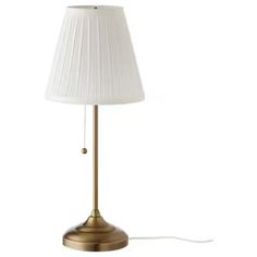 a lamp with a white shade on top of it and a cord attached to the base