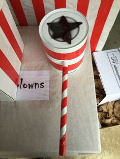 a red and white striped cone with a black star on it sitting in front of a box