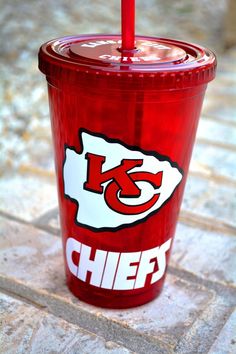 a red plastic cup with the kansas chiefs logo and a straw sticking out of it