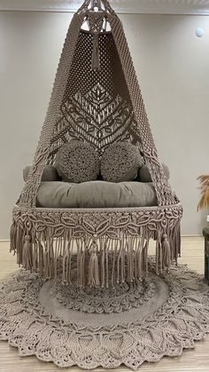 a bed made out of crochet and tassels with pillows on it