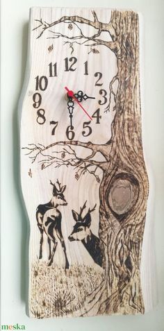 a wooden clock with an image of two deers in the woods on it's face