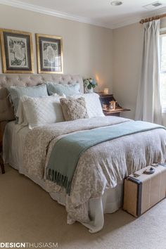 a bedroom with a large bed and two pictures on the wall