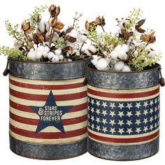 two tin canisters with flowers and cotton balls in them, one painted red white and blue