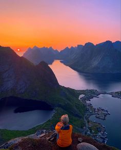 a person sitting on top of a mountain looking at the sunset