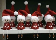 a row of red and white santa hats sitting on top of a shelf