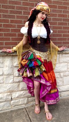 a woman in a costume standing next to a brick wall