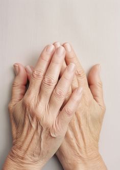 an older woman holding her hands together with both hands on top of the other hand