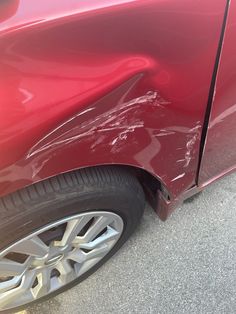 the front end of a red car that has been dented